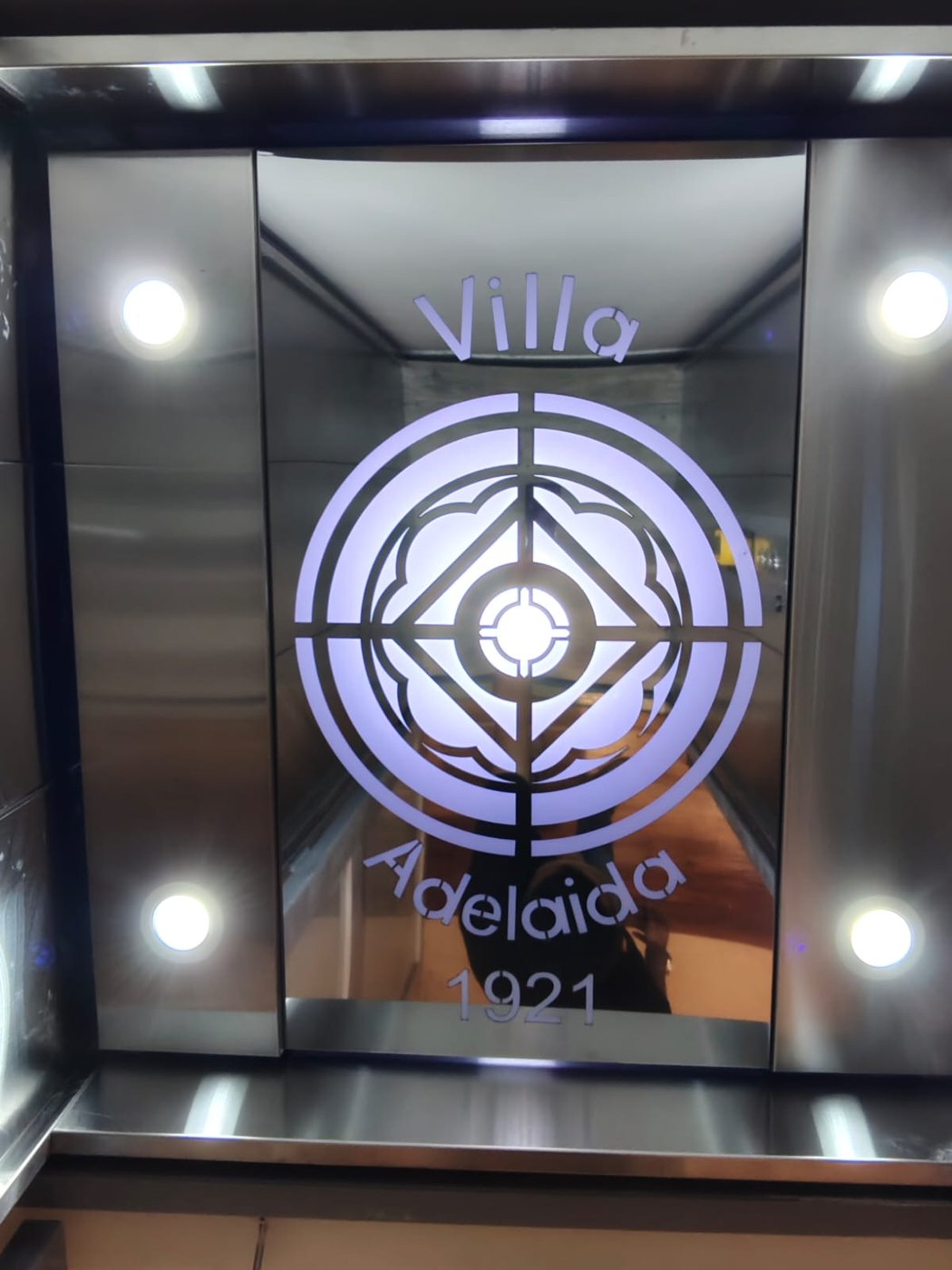 Techo de cabina en acero inoxidable con el escudo Villa Adelaida 1921 grabado y retroiluminado